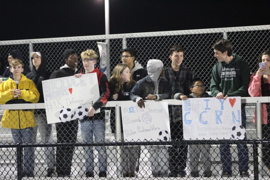 Fans support the team with signs. 