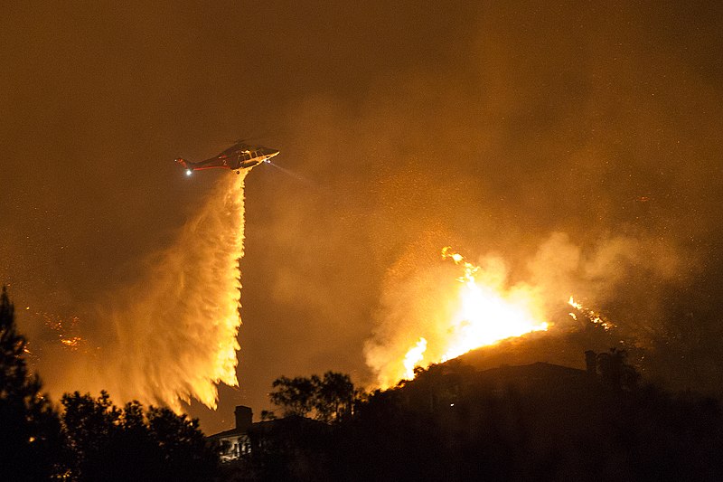 A helicopter dropping water to help maintain the fires. 