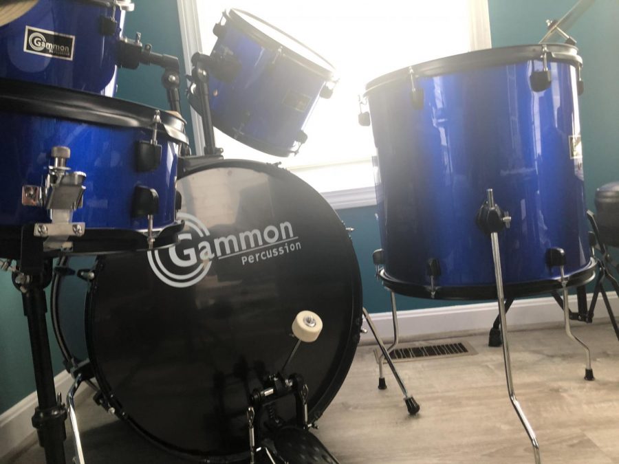A full view of a drum set with the bass drum, two high toms, and the low tom.