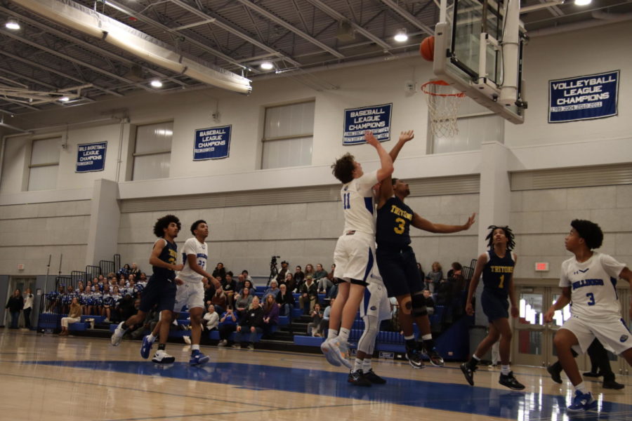 Owen Burke makes a layup as hes being blocked by Triton players
