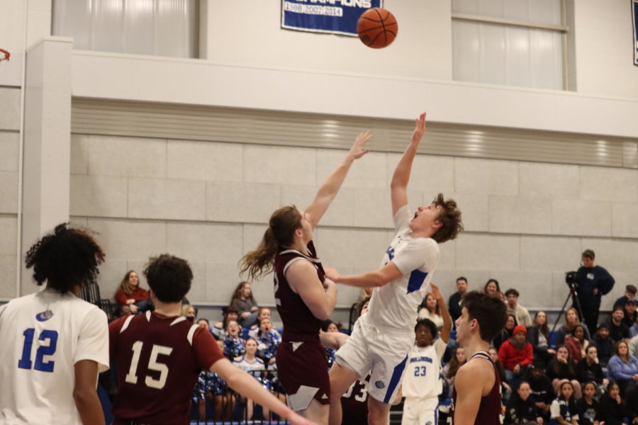 Owen Burke shooting a successful layup while being guarded by opposing team player