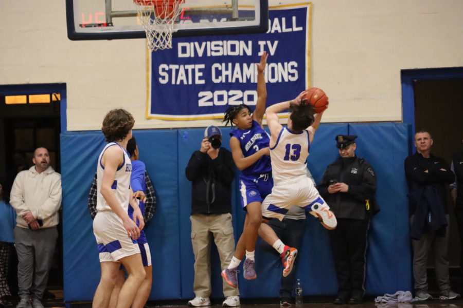 Allen Brown JR jumps off the ground to guard #13 for Hopedale