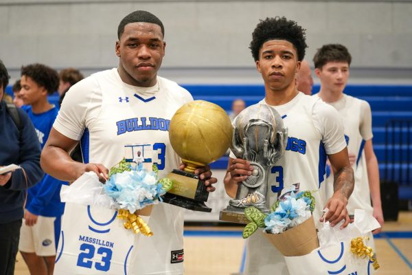 Allen Brown (#3) and Odens Massillion (#23) stand together and hold their trophies after both reached career milestones in the same game: Brown surpassing 2,000 points, and Massillion scoring his 1,000th career point. 