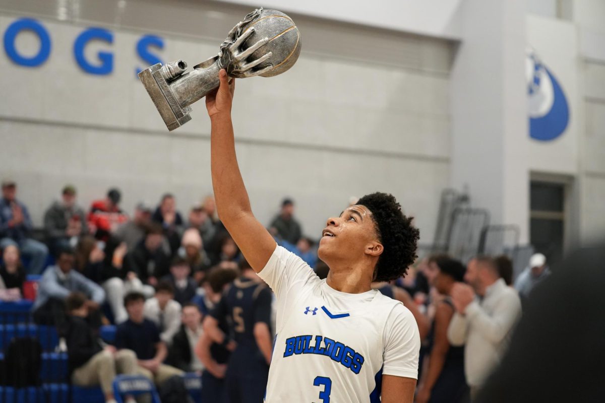 Allen Brown Jr. (#3) raises his Trophy after becoming the first Boys Varsity Basketball player in Holbrook History to reach 2,000 career points during a game vs. East Bridgewater High School.